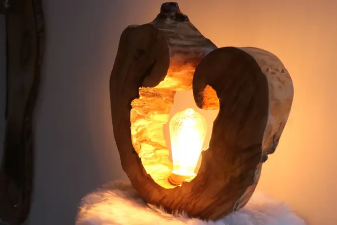 Lampe design en bois sculpté avec ampoule allumée, ambiance chaleureuse et naturelle