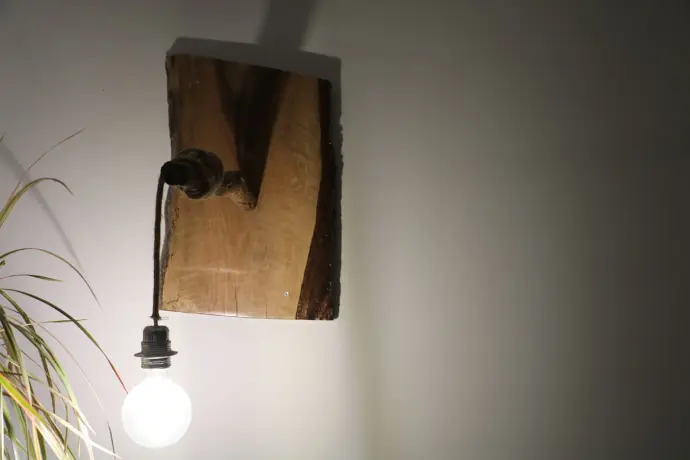 Lampe allumée suspendue en bois naturel avec ampoule ronde, design minimaliste et rustique